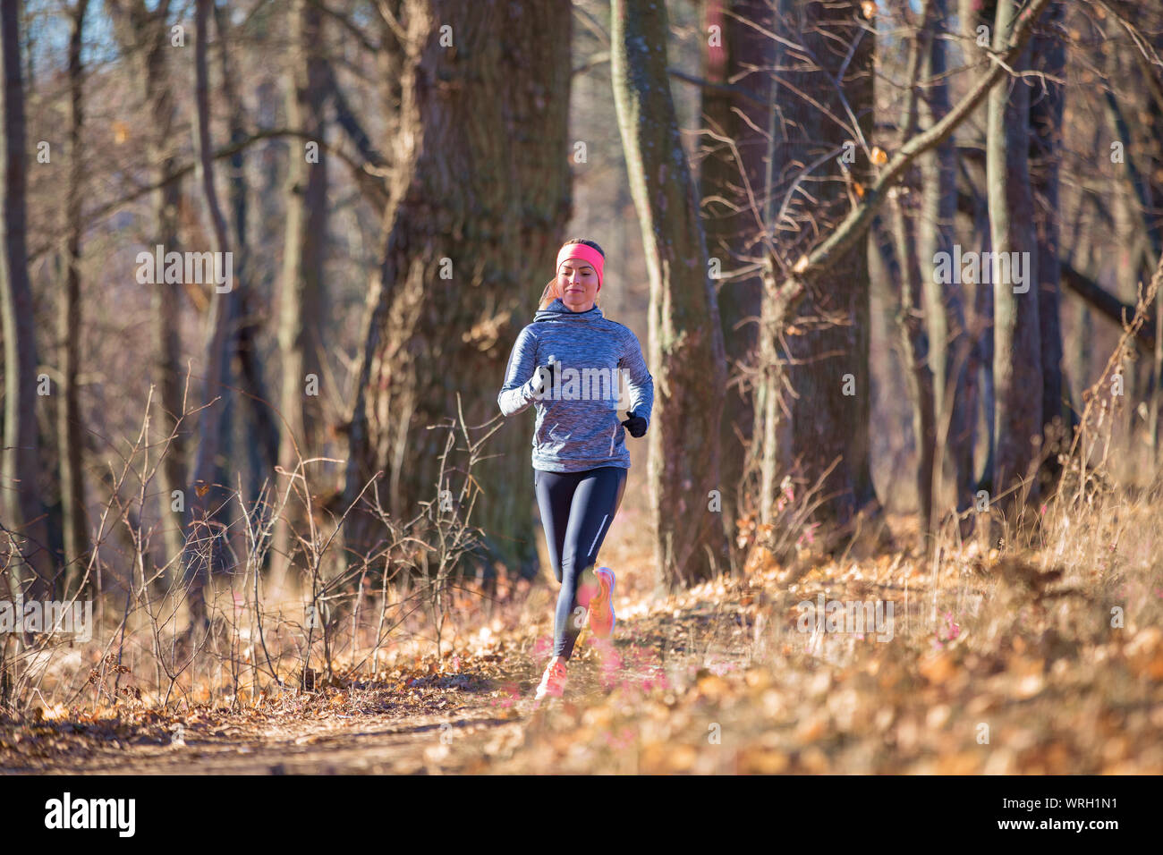 Joven Mujer fitness corriendo en el parque en la mañana de otoño. Vida sana de fondo para correr Foto de stock