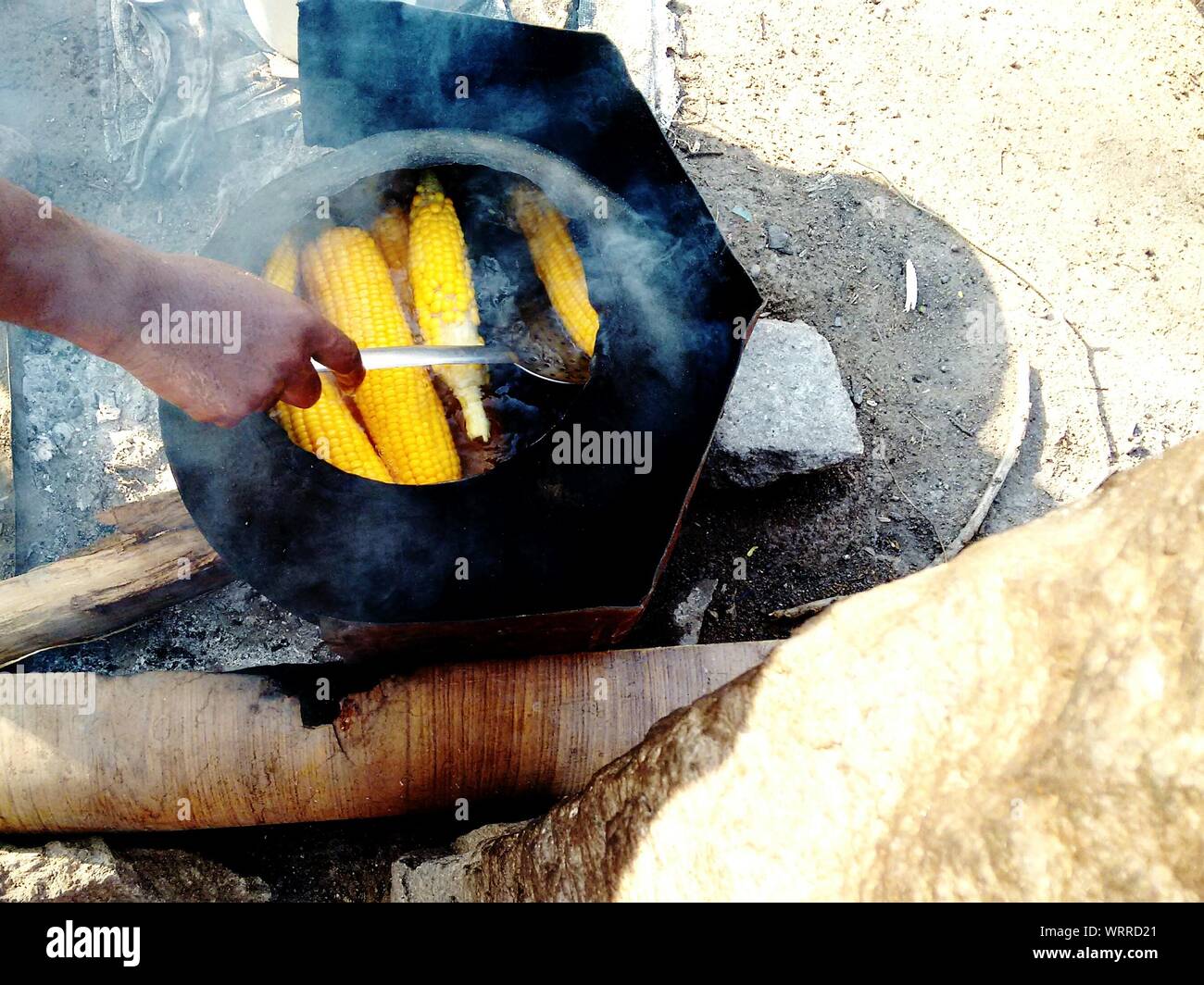 Imagen recortada del hombre preparar Maíz en barbacoa de carbón Foto de stock