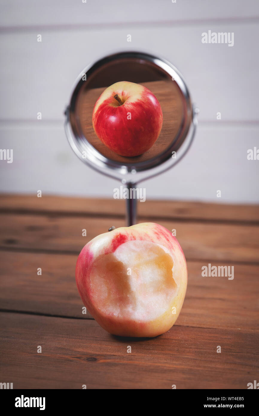 Las expectativas y la realidad concepto - manzana mordida con espejo perfecto reflejo Foto de stock