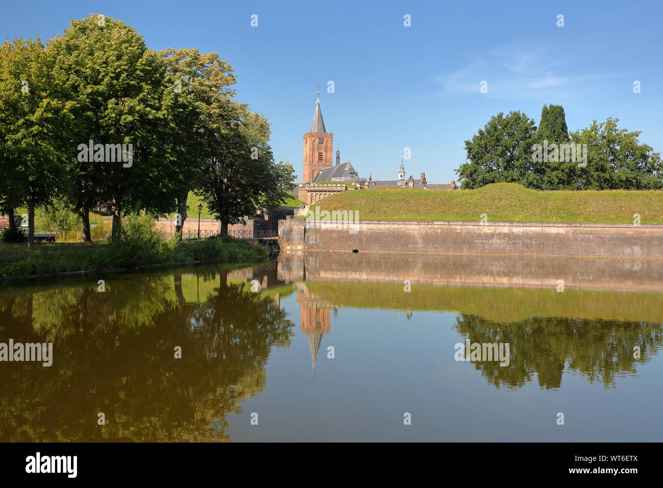 Las murallas y fosos de la ciudad de Naarden, Holanda, con la Grote Kerk iglesia en el fondo Foto de stock
