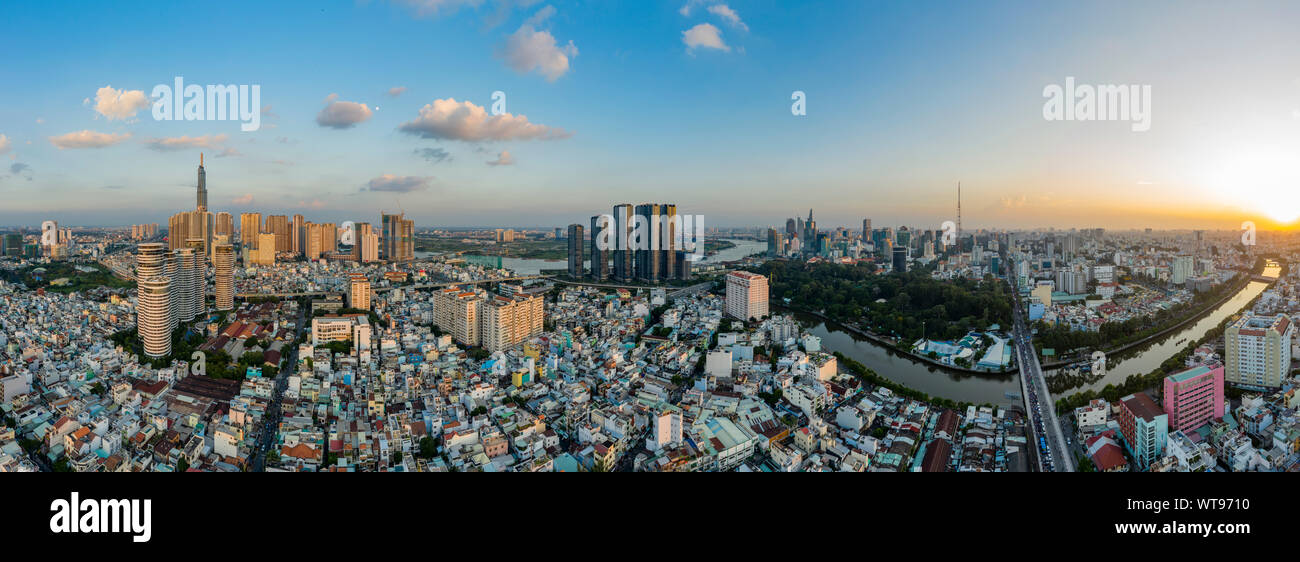 Ultra alta resolución antena dramático panorama de Binh Thanh district Ho Chi Minh tomando en los principales edificios de la ciudad y enfrente del río al atardecer Foto de stock