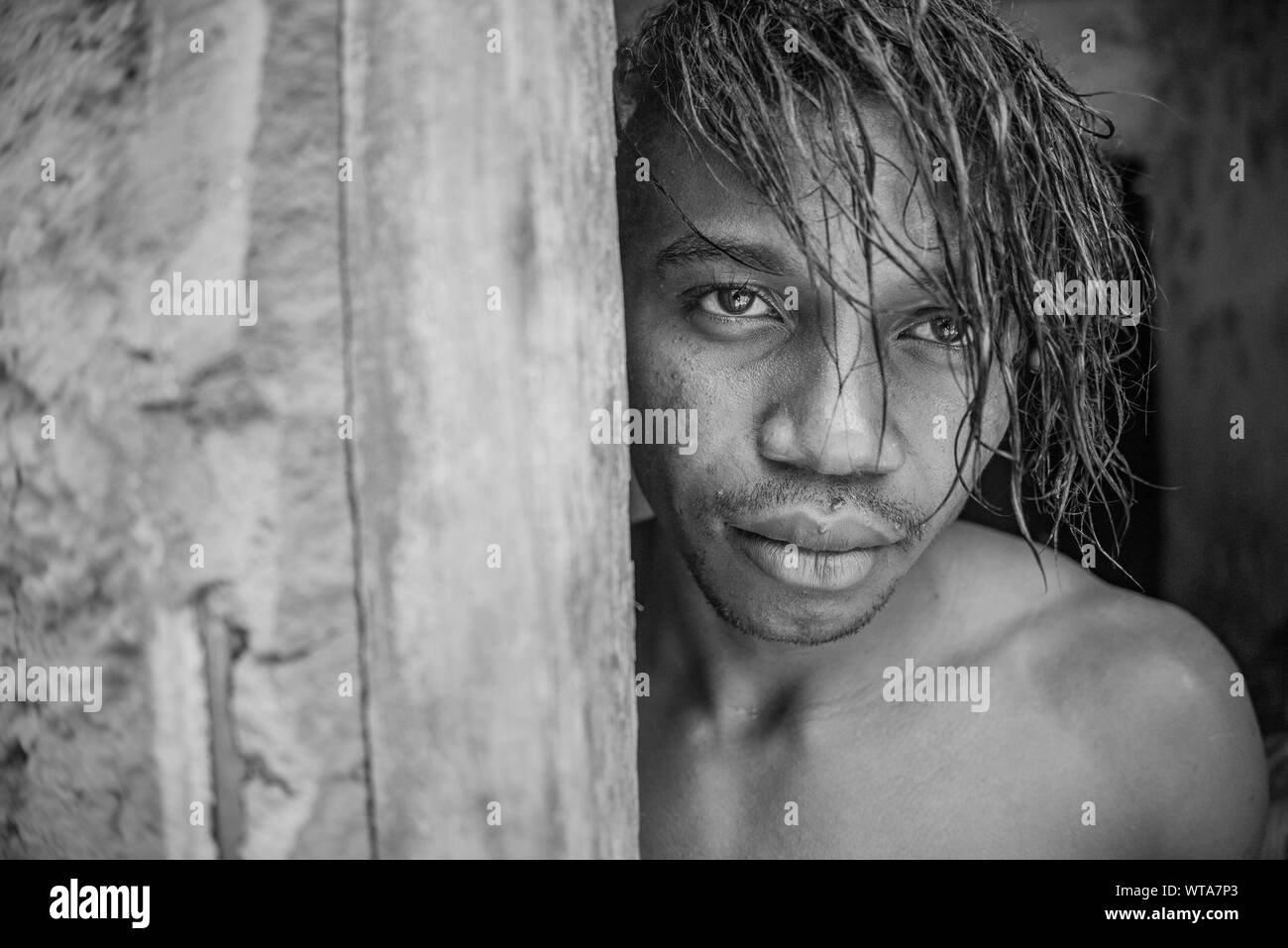 Hombre de pie en la puerta después de ducha refrescante en el norte brasileño pueblo Foto de stock