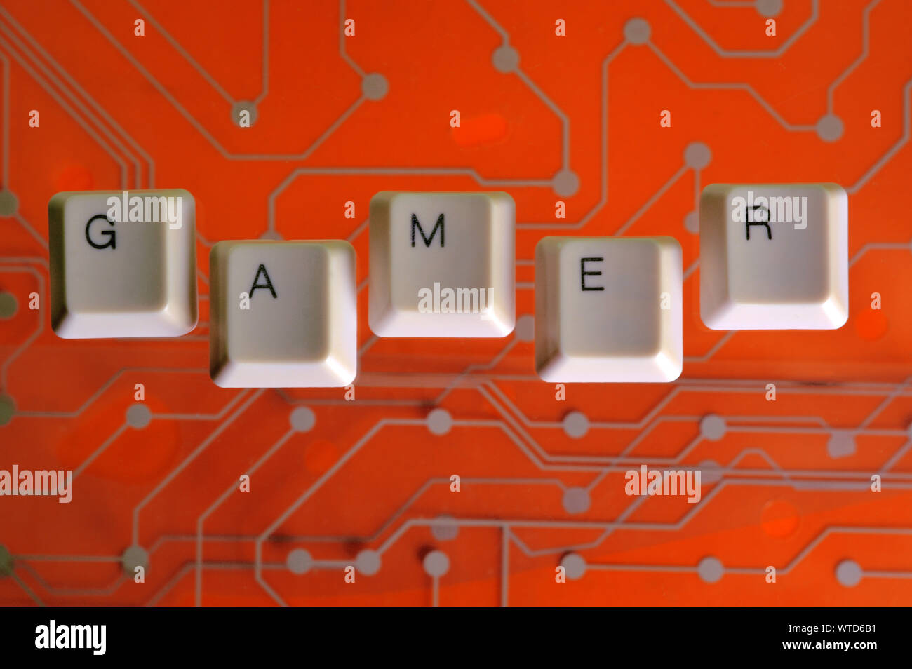 Teclas del teclado forman la palabra Gamer en naranja en el fondo del  circuito eléctrico Fotografía de stock - Alamy