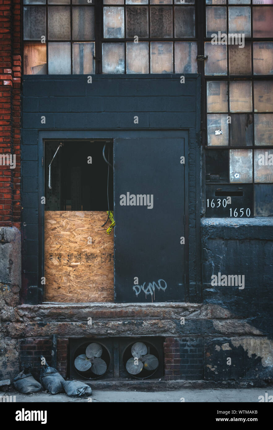 Una puerta de arriba en el exterior de un viejo edificio abandonado. Foto de stock