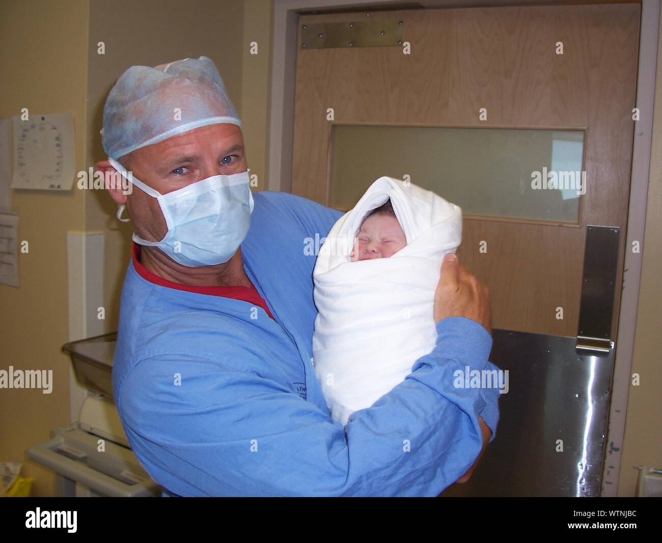 Retrato del Doctor llevando bebé recién nacido en el Hospital Foto de stock