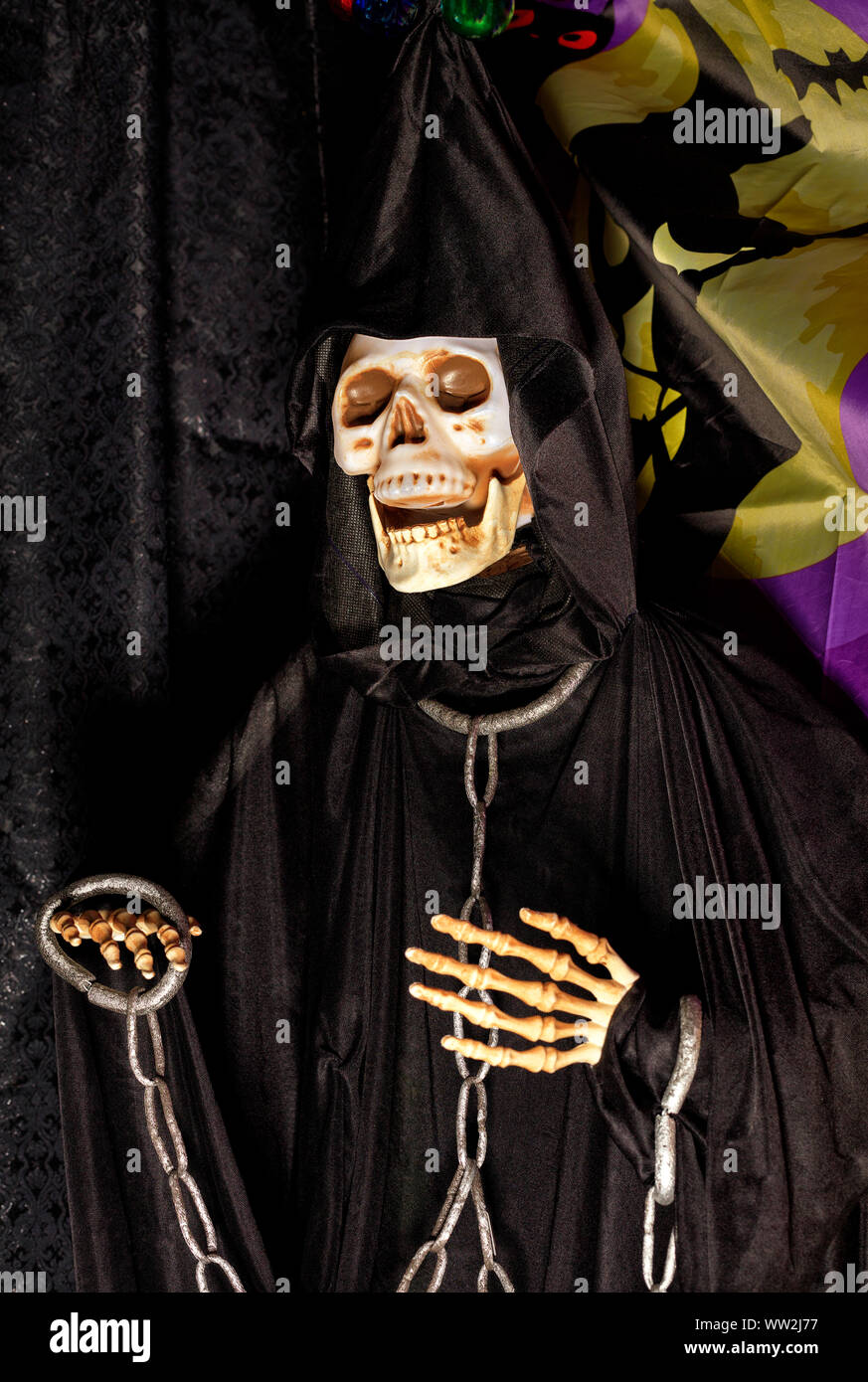 Halloween, la muerte en una muñeca hoodie negro y una capucha en la cabeza  con cadenas de metal en el cuello y los brazos Fotografía de stock - Alamy