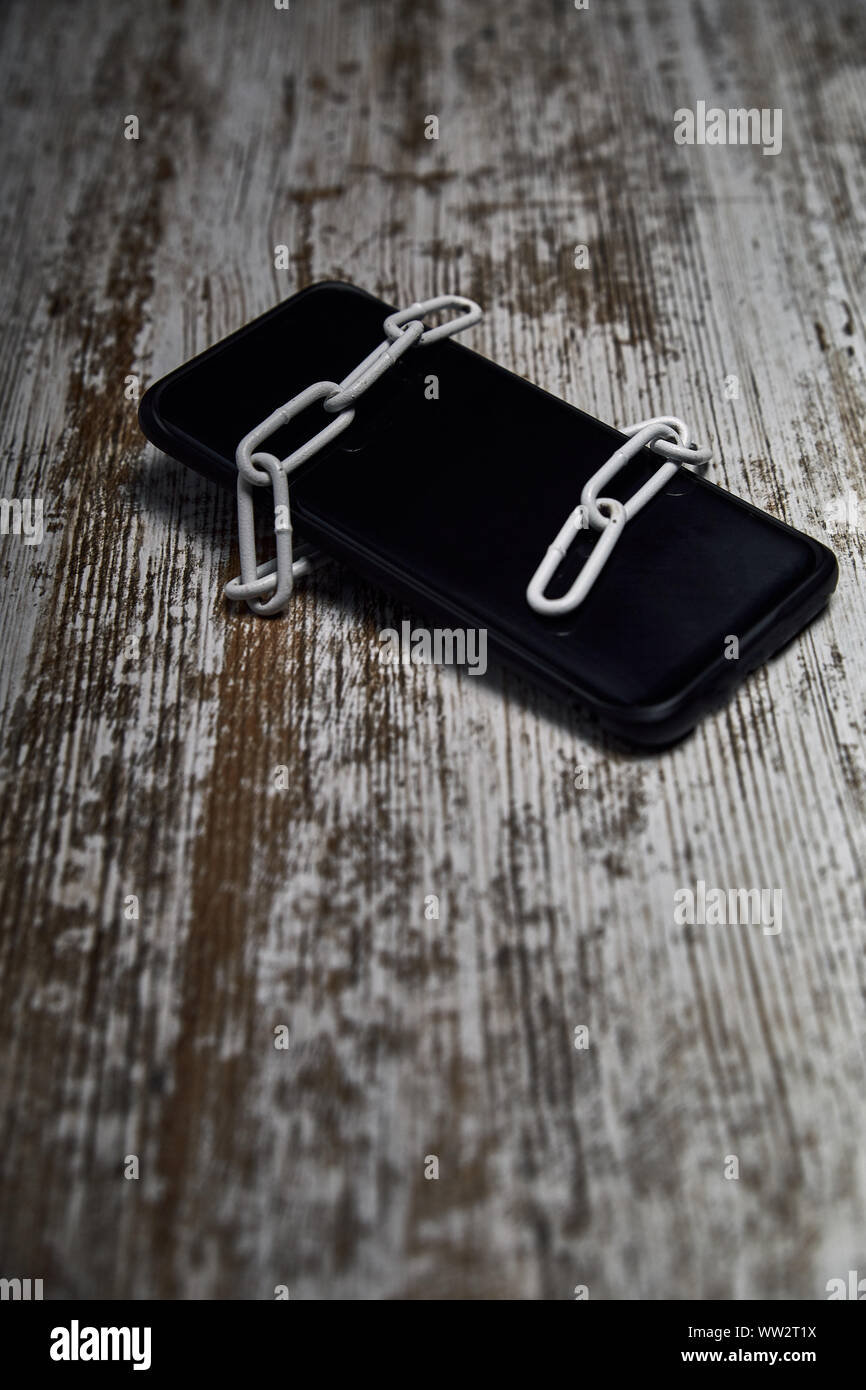 Mobile atado con una cadena para simular la seguridad contra virus Foto de stock