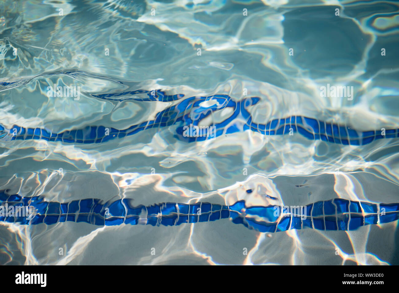 Rip olas en una piscina encima de azulejos azules Foto de stock