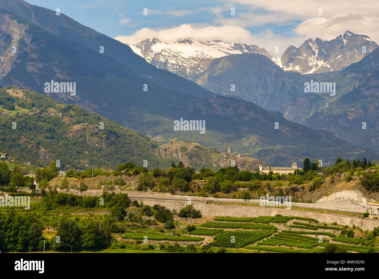 Vista elevada del valle con el priorato de Saint-Pierre, las ruinas de Châtel-Argent castillo en Villeneuve y el rango de Mont Blanc, Aosta, Italia Foto de stock