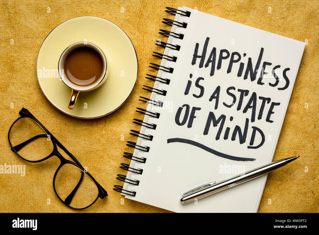 La felicidad es un estado de ánimo - inspiradoras de la escritura a mano en un cuaderno de espiral con café, éxito, positividad y el concepto de desarrollo personal Foto de stock