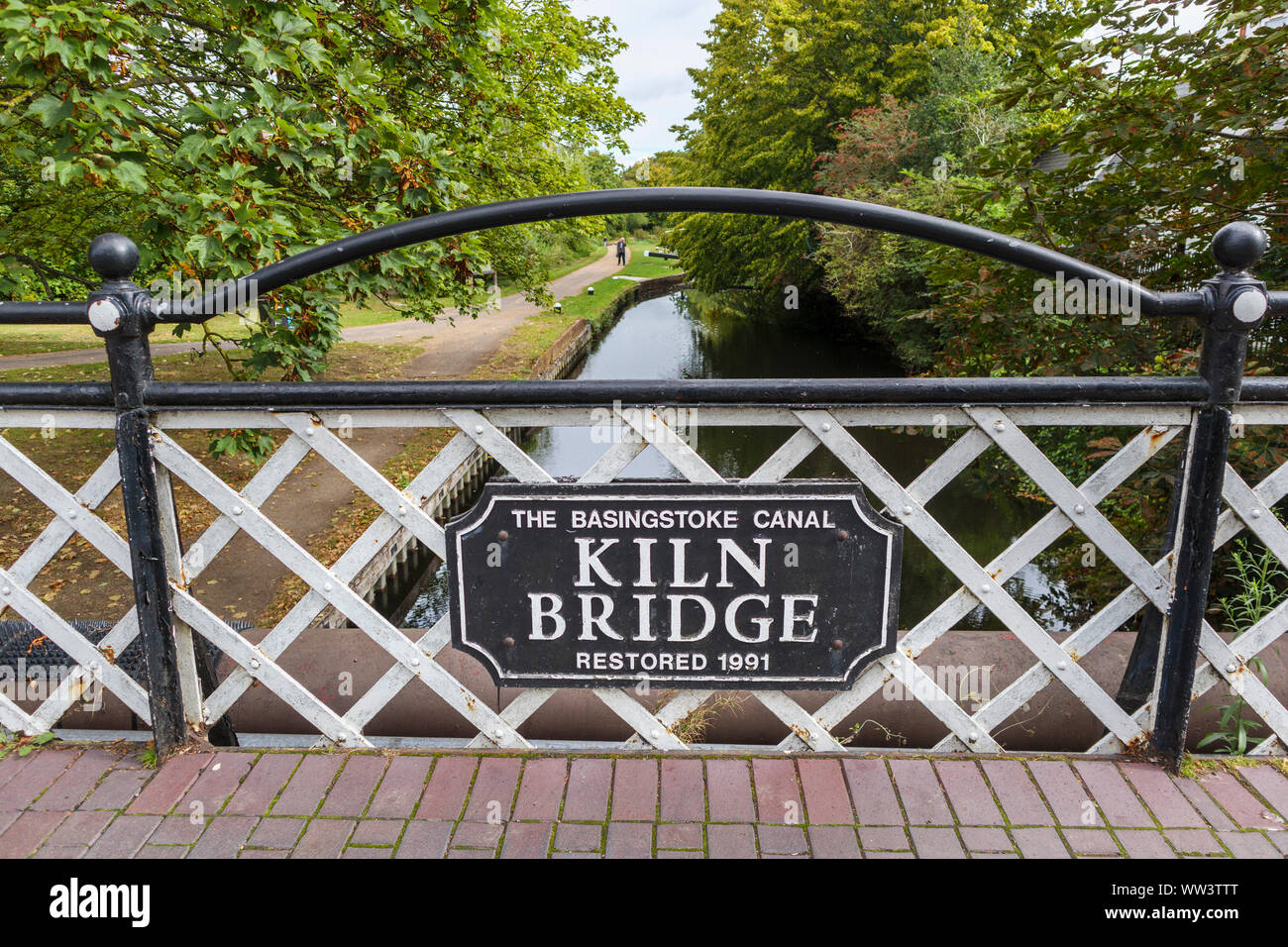 Horno Puente, una carretera, un puente sobre el canal de Basingstoke con una placa con el nombre de St John's Village, cerca de Woking, Surrey, sudeste de Inglaterra, Reino Unido. Foto de stock