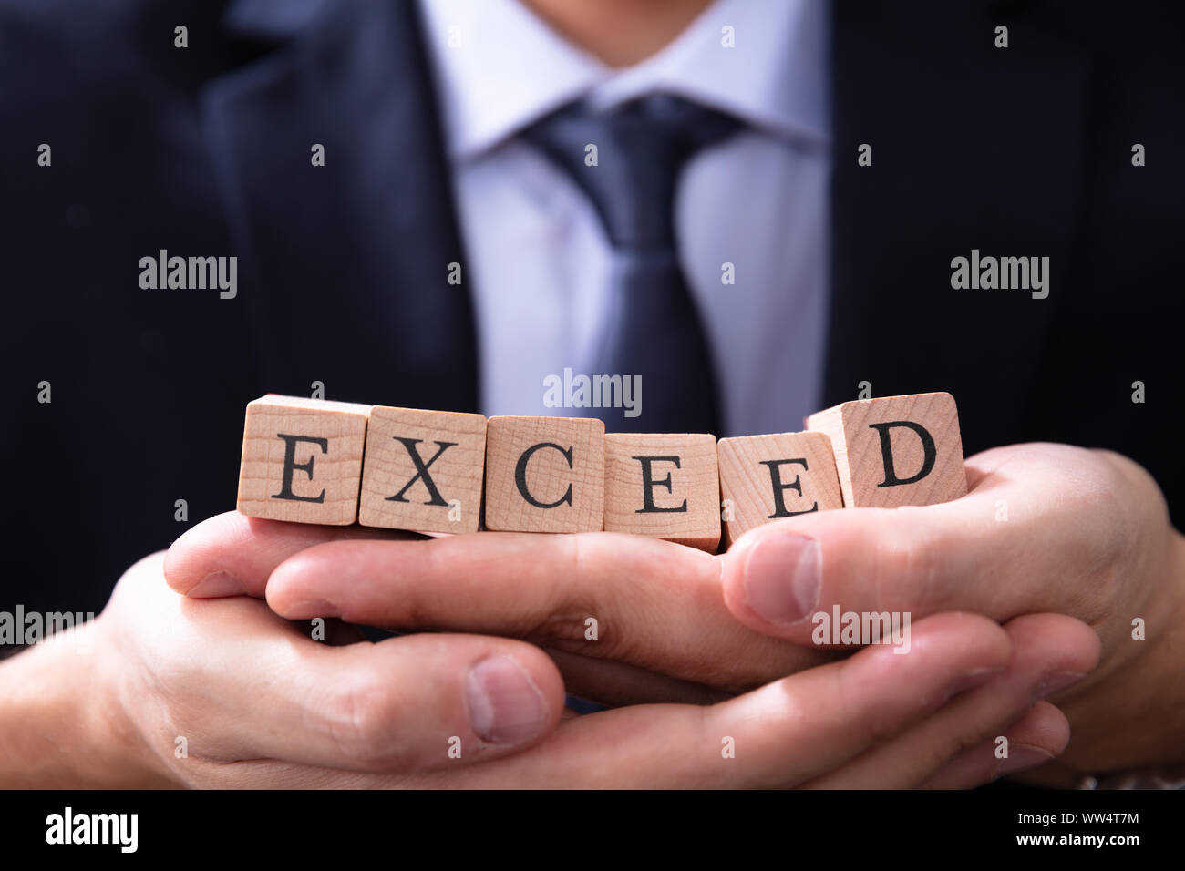 Empresario celebración supere las expectativas Palabra en sus manos Foto de stock