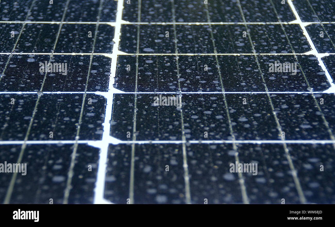 Paneles de energía solar fotovoltaica en la lluvia. Gotas de agua en la celda de vidrio. Foto de stock