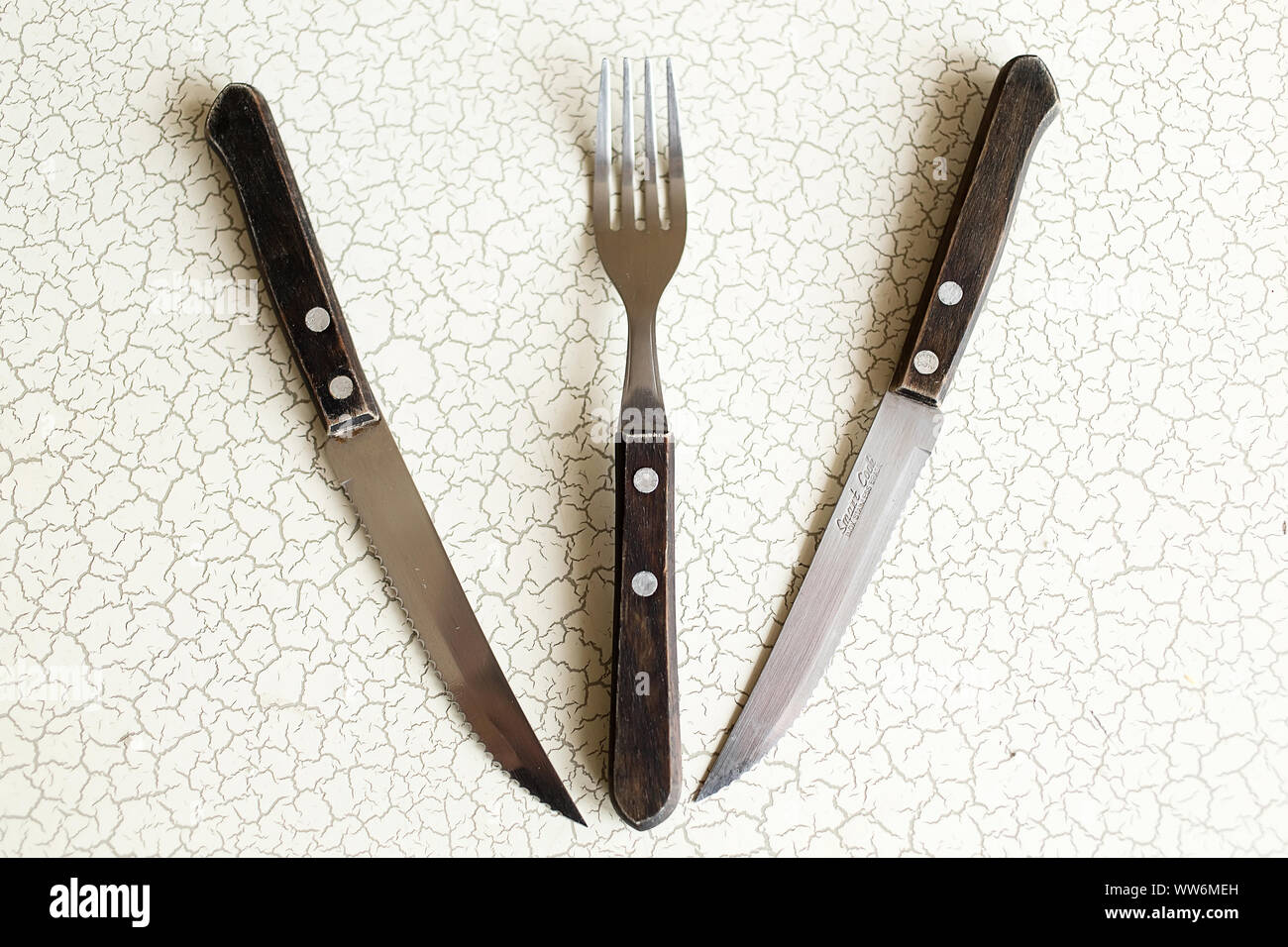 Cubertería. Composición de la cuchillería dos cuchillo y tenedor en la mesa  constituyen una forma geométrica triángulo. La composición de la cuchillería  Fotografía de stock - Alamy