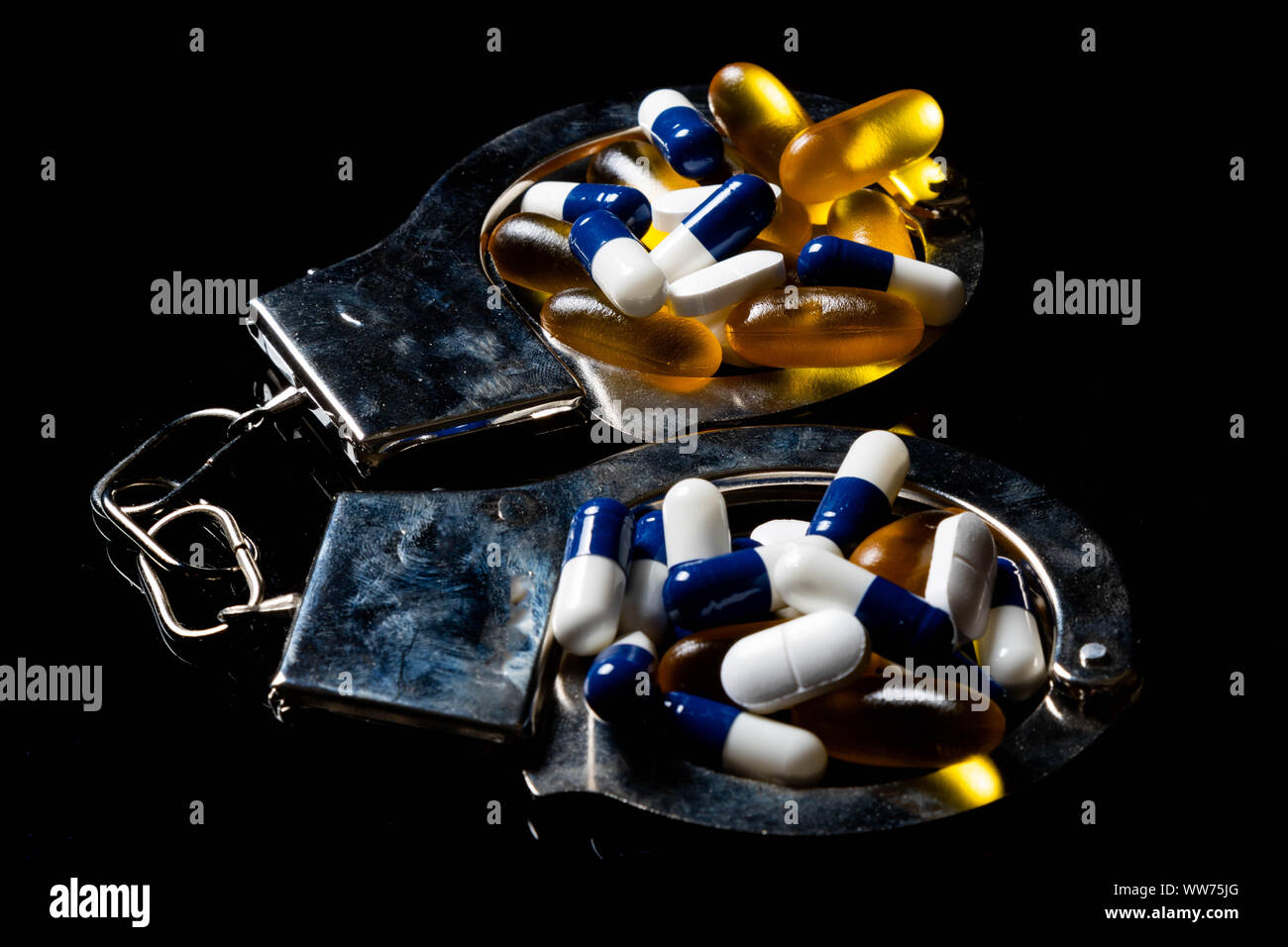 Crisis de drogas ilegales concepto mostrando las píldoras y las esposas  Fotografía de stock - Alamy