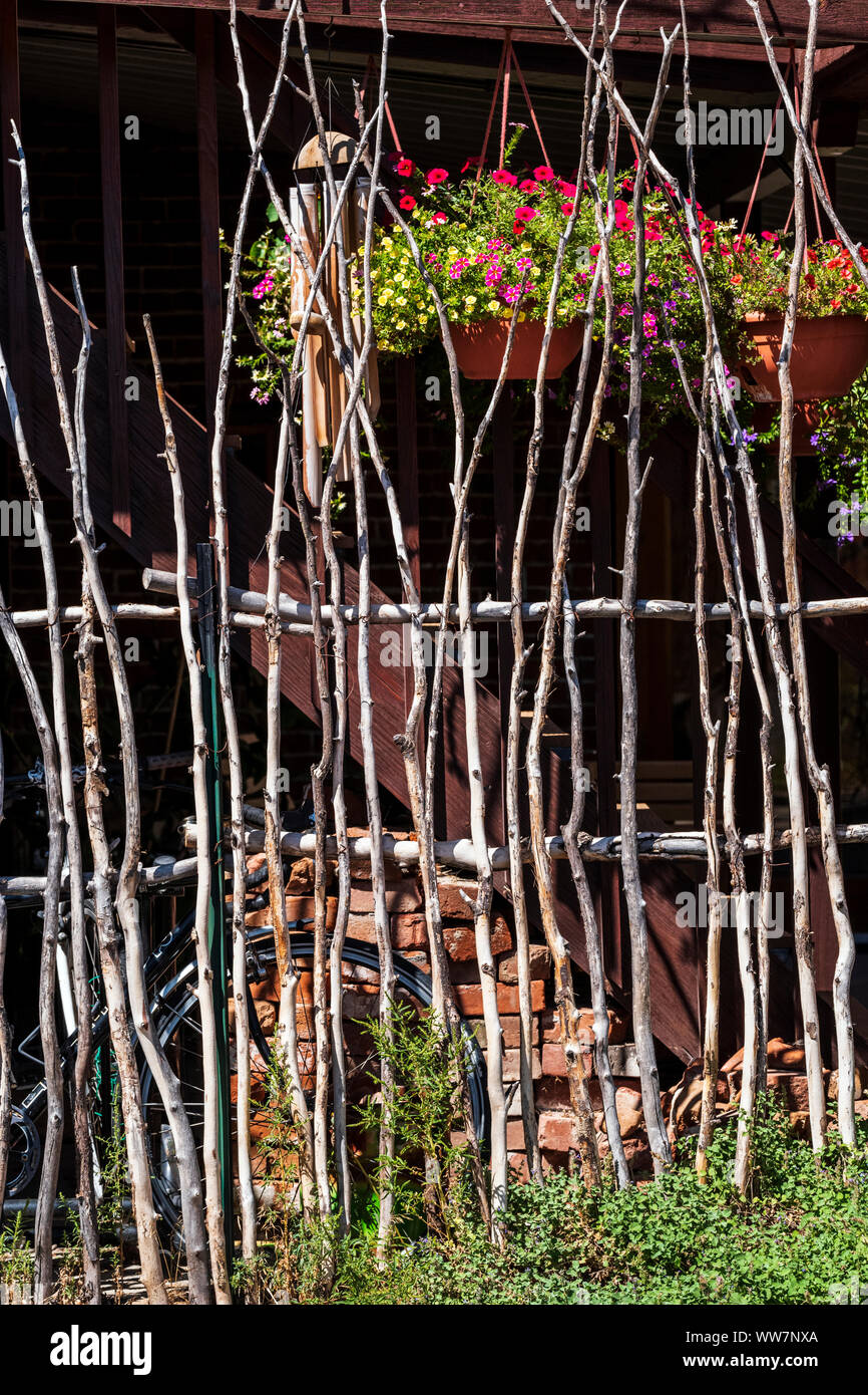 Palos de madera áspera crear cerco rústico natural único; flores colgantes;  114 East 1st St.; Salida, Colorado, EE.UU Fotografía de stock - Alamy