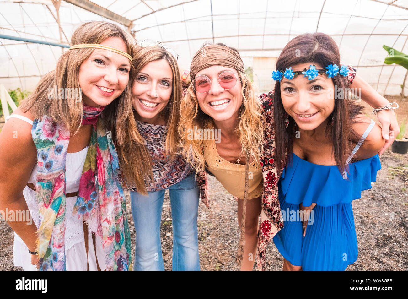 Cuatro jóvenes y bellas mujeres alegres en un selfie abrazando juntos en amistad, coloridos vestidos y ropa hippie en libertad y estilo sonrisas y concepto personas caucásicas Fotografía de