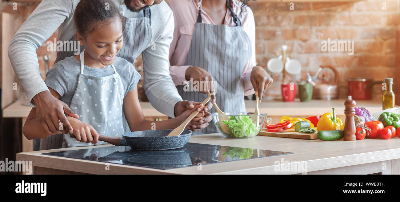 Linda muchacha africana aprender a cocinar comida saludable Foto de stock