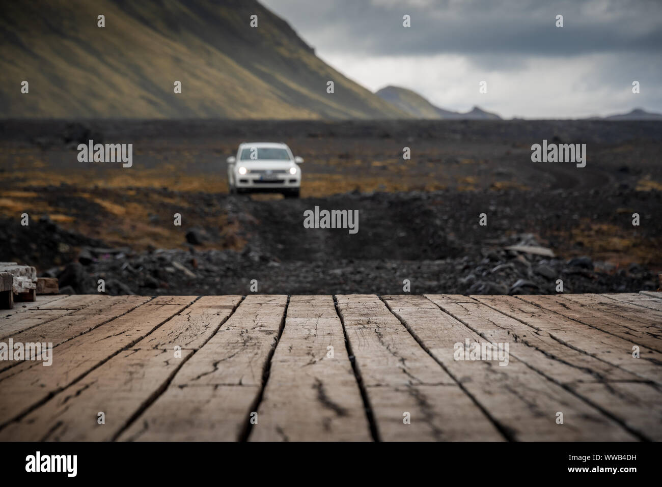 Coche acercándose al puente de madera en el sendero laugavegur, Islandia Foto de stock