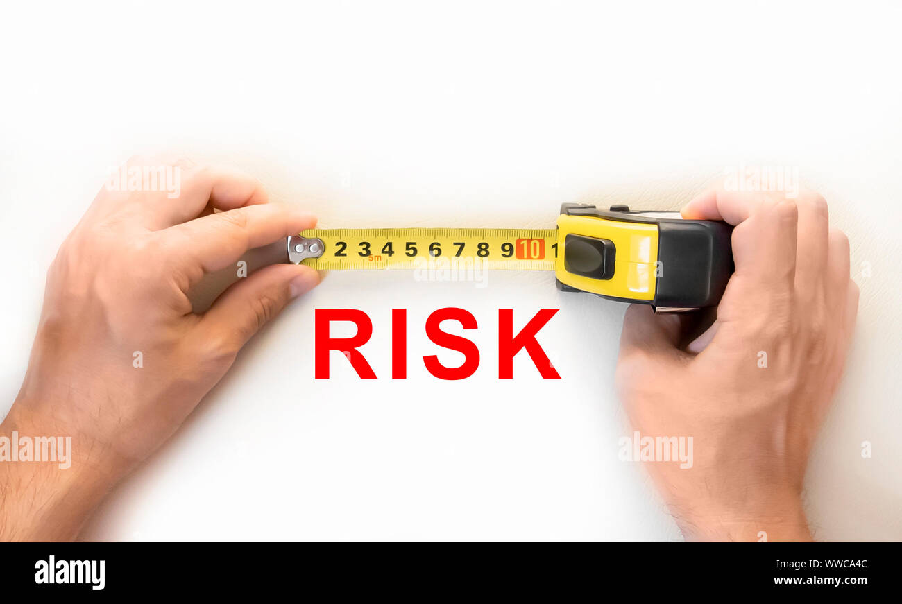 Manos sosteniendo la medida de riesgo de medición cinta Fotografía de stock  - Alamy
