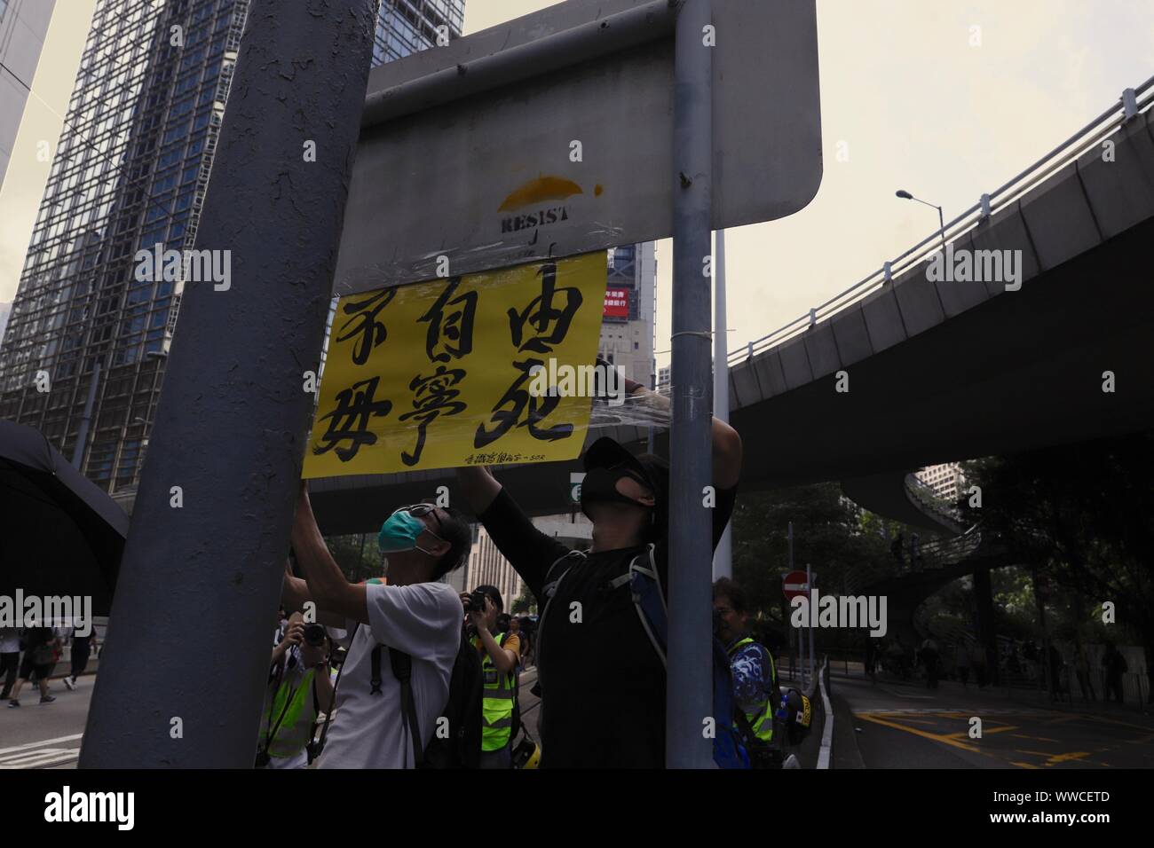 Hong Kong, China. 15 Sep, 2019. Los manifestantes son vistos aquí tratando de pegar la etiqueta que lee y morir, SI NO GRATUITA en un cartel durante una marcha de protesta el domingo.sept-15, 2019 Hong Kong.ZUMA/Liau Chung-ren Crédito: Liau Chung-ren/Zuma alambre/Alamy Live News Foto de stock