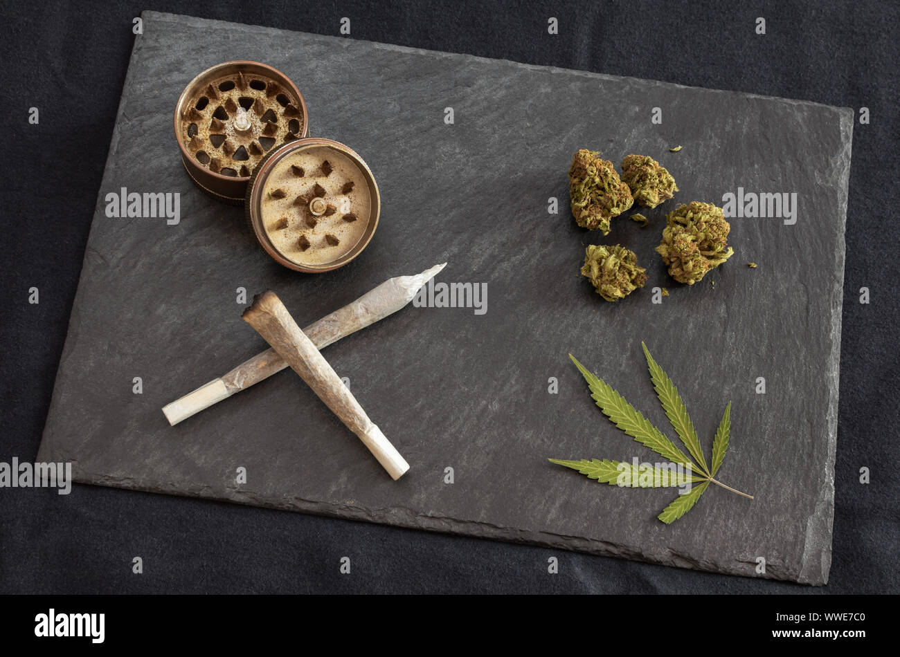 Articulaciones listo para fumar marihuana, cogollos de cannabis de alta  calidad, molinillo y marihuana leaf en piedra negra bandeja de malezas  Gourmet sobre fondo oscuro Fotografía de stock - Alamy