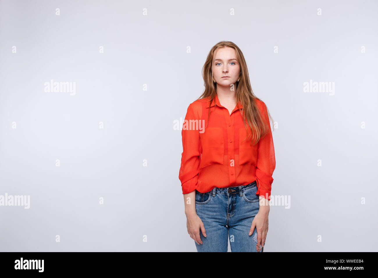 Malestar joven vistiendo una blusa roja y jeans Fotografía de stock - Alamy