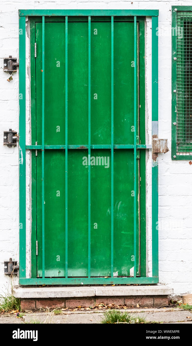 Un verde puerta asegurada por barras de metal. Foto de stock