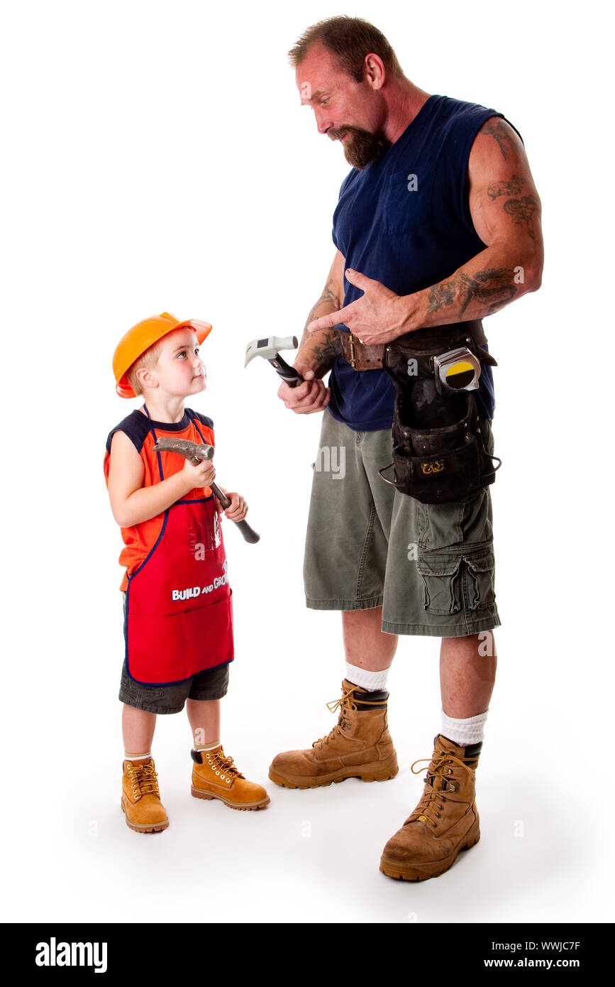 Un hombre fornido padre con su hijo, carpinteros, los martillos mientras el papá está explicando por apuntando a su herramienta, aislado Fotografía de stock - Alamy