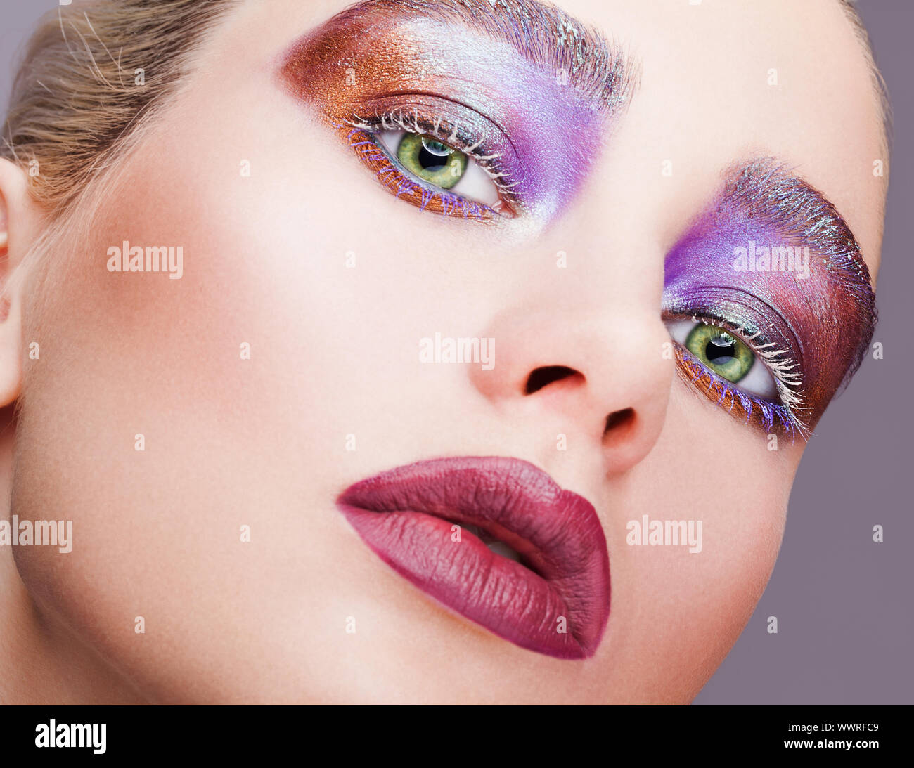 Hembra de color verde pistacho ojo ojos violeta noche con sombras, pestañas  en blanco y morado maquillaje labios Fotografía de stock - Alamy