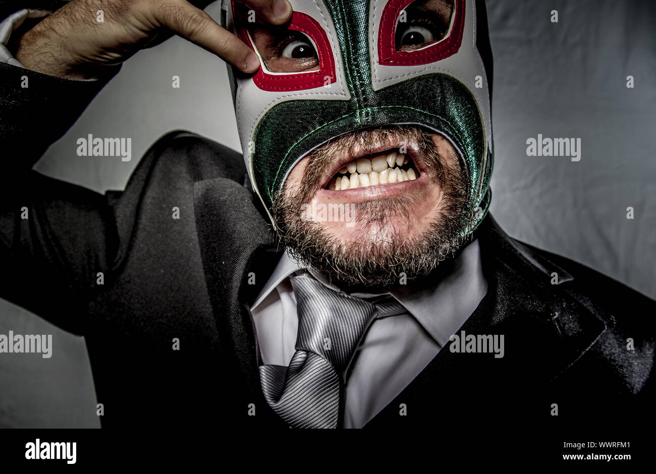 Empresario enojado con máscara de luchador mexicano, vestido con traje