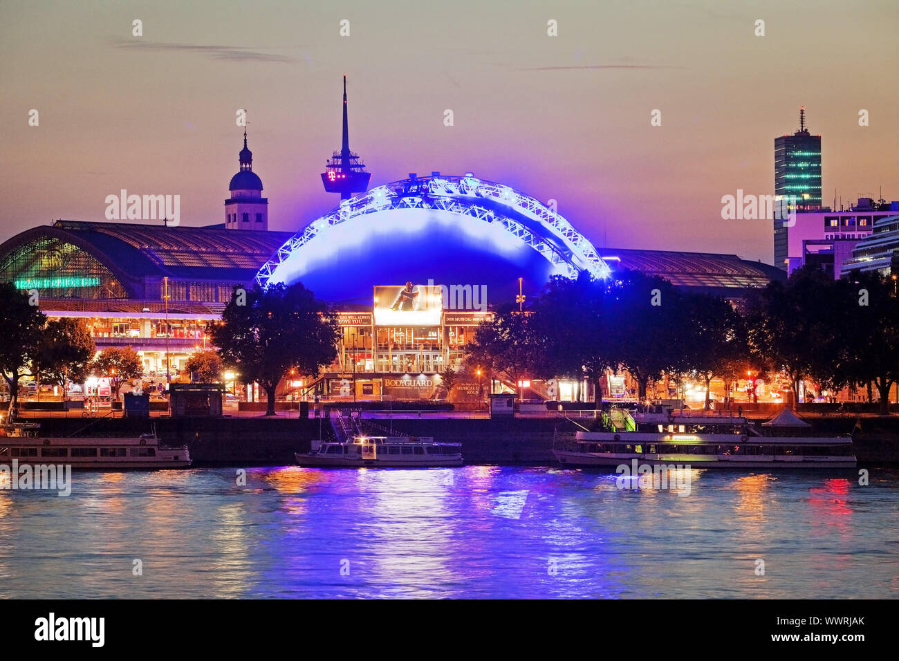 Panorama de la ciudad con la estación central, el río Rhein y Musical Dome en el crepúsculo, Colonia, Alemania Foto de stock
