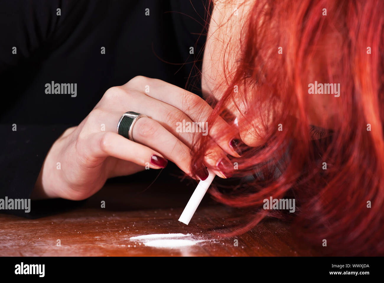 Mujer joven Esnifar cocaína en polvo a través de un tubo enrollado  Fotografía de stock - Alamy
