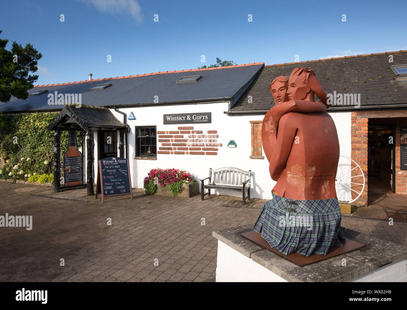 Los amantes de escultura en el patio de la vieja de la tienda del herrero en Gretna Green, Scotland, Reino Unido Foto de stock