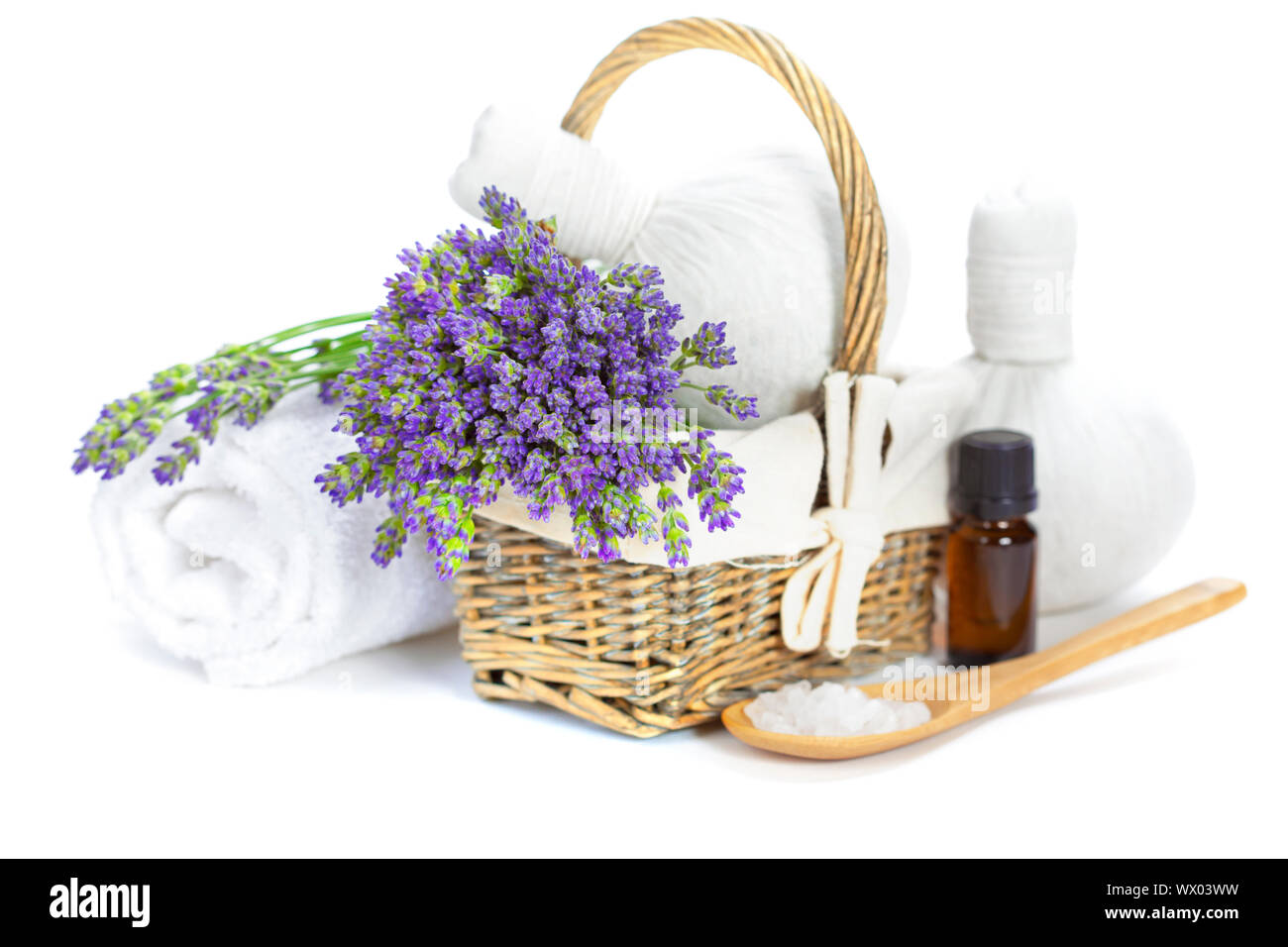 Spa (lavanda fresca en una canasta de flores de lavanda, aceite esencial, la sal, el masaje herbario bolas) sobre blanco Foto de stock