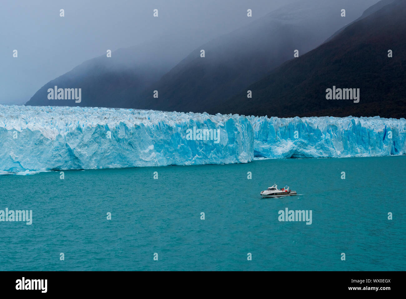 Barco turístico en el frente del Glaciar Perito Moreno en el Parque Nacional Los Glaciares, declarado Patrimonio de la Humanidad por la UNESCO, Provincia de Santa Cruz, Patagonia, Argentina Foto de stock