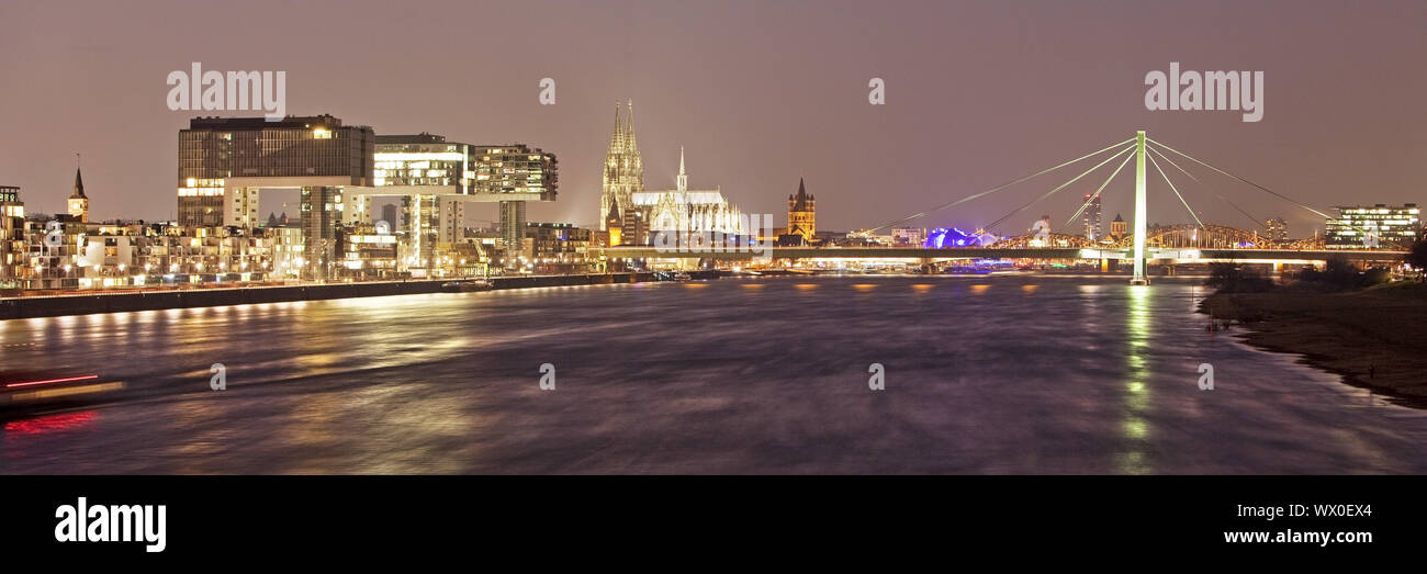 Construcciones de grúa en el rin con la catedral de Colonia al atardecer, Colonia, Renania, Alemania, Europa Foto de stock
