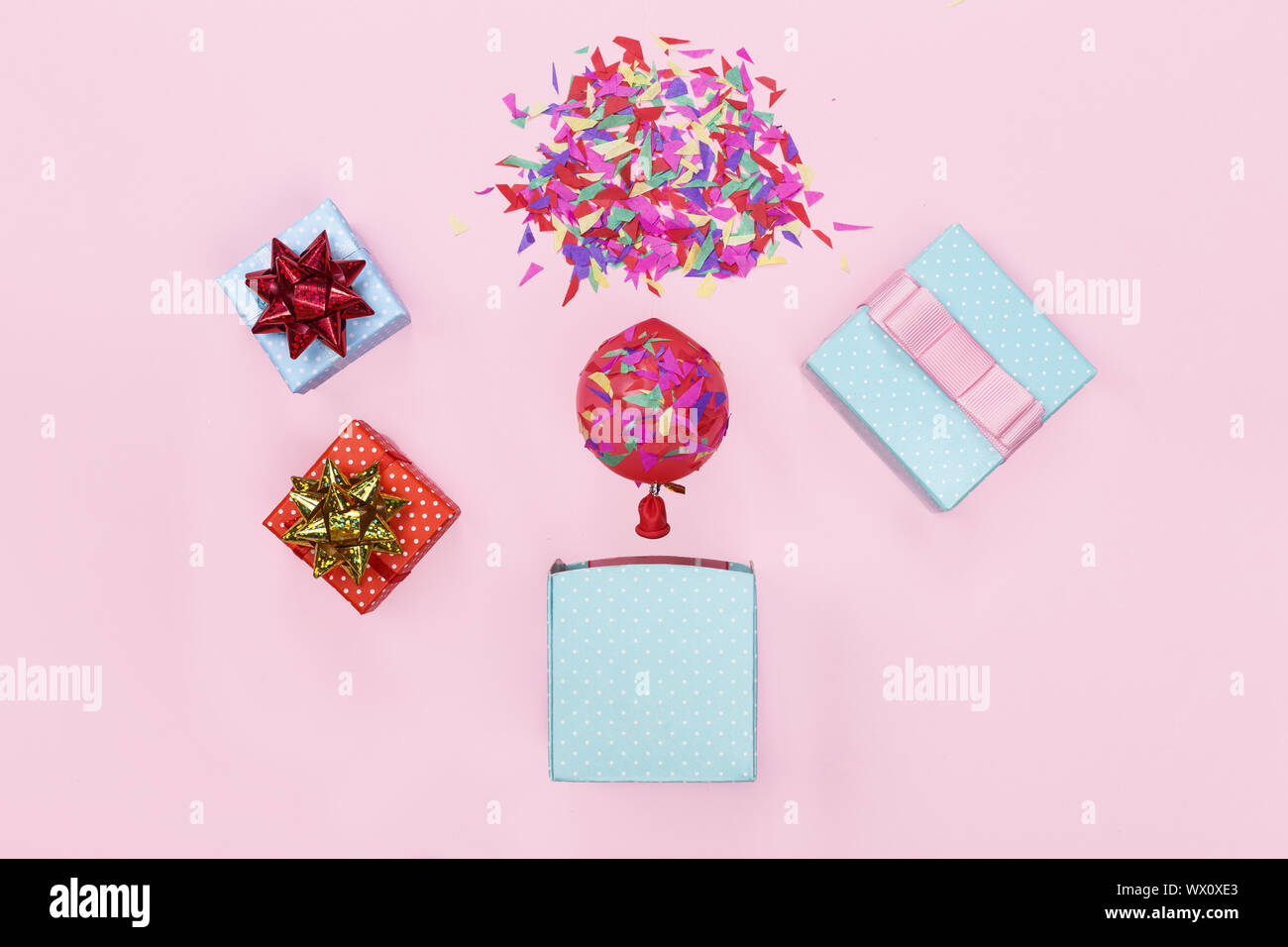 El minimalismo. Una maqueta de una tarjeta de felicitación. Caja de regalo, globos, confeti, parte backgro feliz cumpleaños. Foto de stock