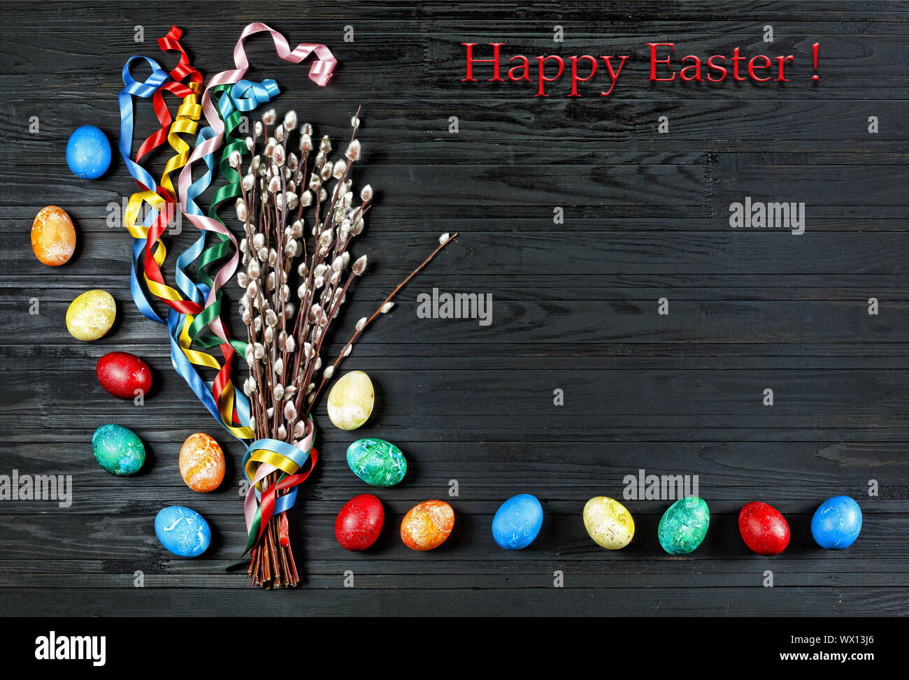 Pascua, símbolos de Pascua, huevos de Pascua, pussy willow , cintas de colores, fondo negro, madera backg Foto de stock