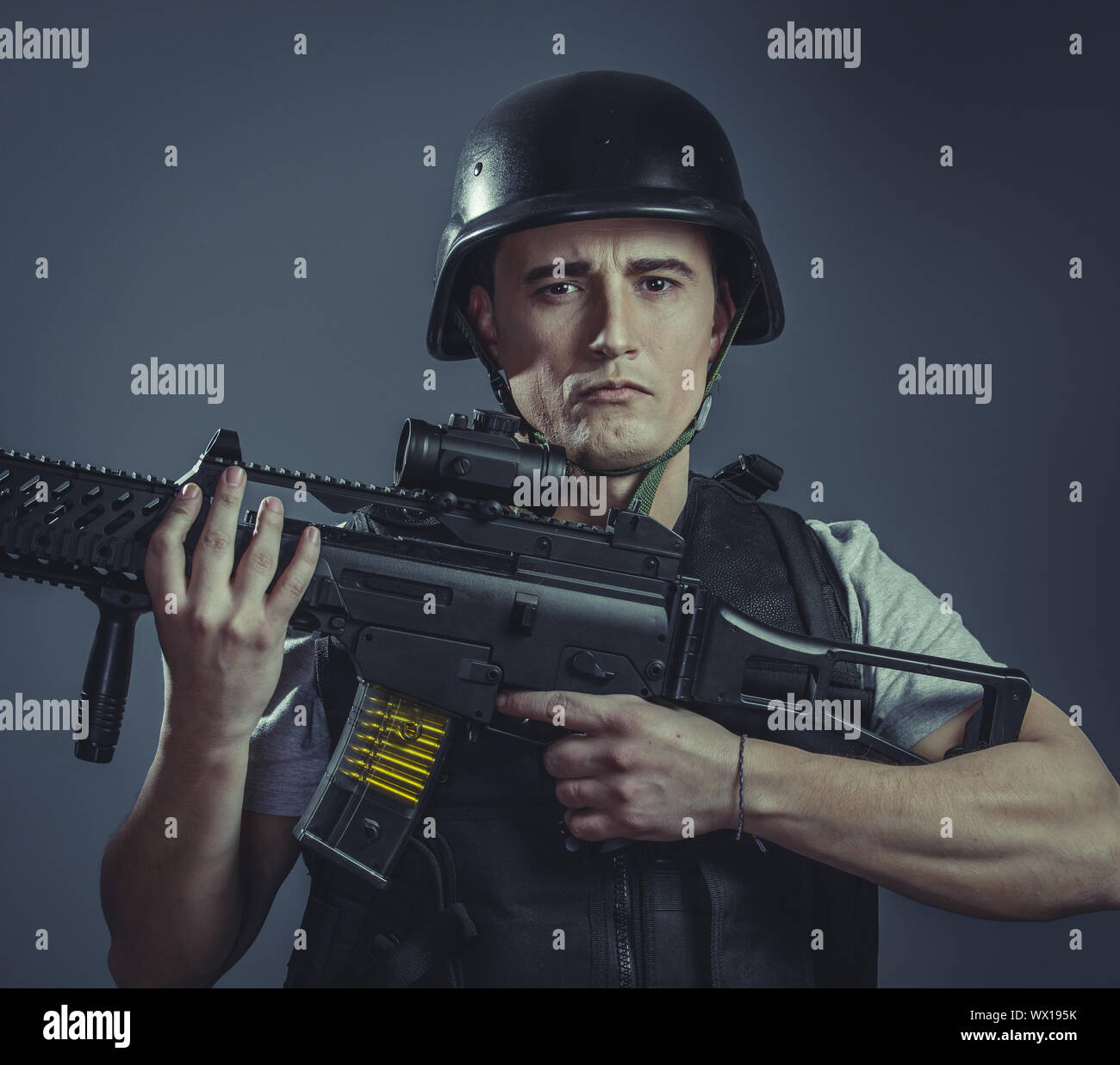 Ocio, deporte de paintball jugador lleva casco protector apuntando