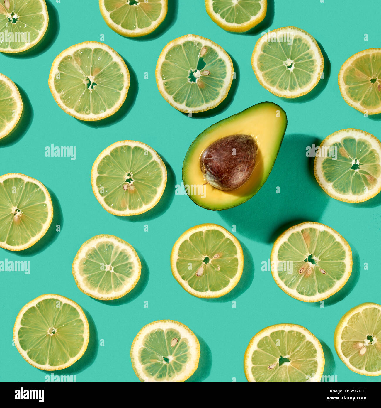 Patrón orgánica fresca natural con limón frutas y solo la mitad de aguacate  pastel sobre un fondo verde. Sentar planas Fotografía de stock - Alamy