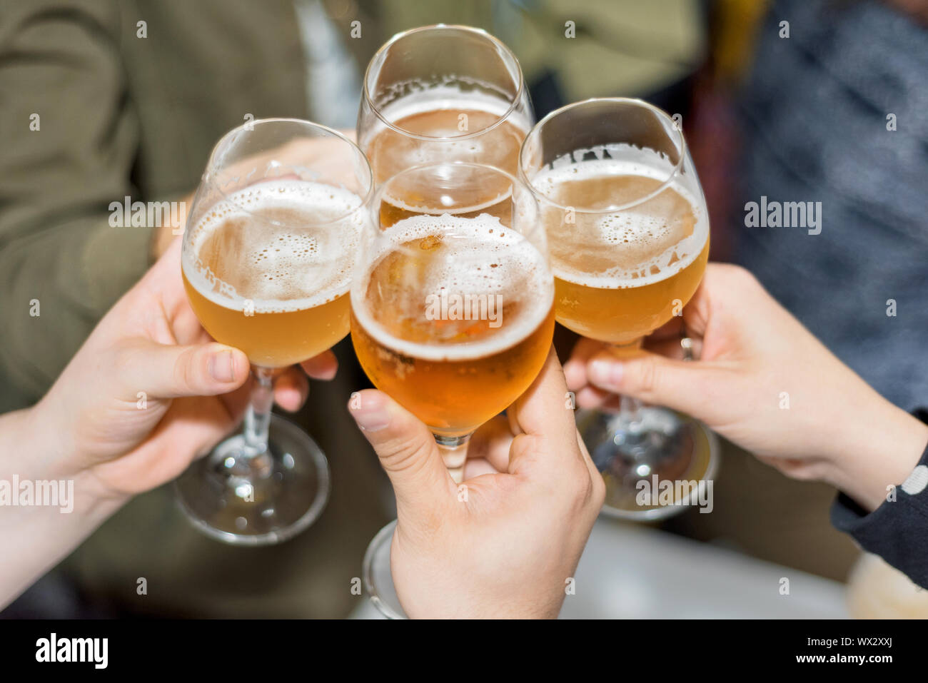 Grupo de Amigos bebiendo cerveza, tostado, en pub Foto de stock