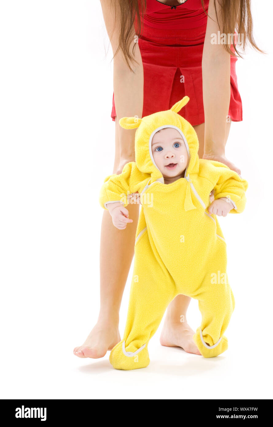 Bebé en traje color amarillo haciendo los primeros pasos Fotografía de  stock - Alamy