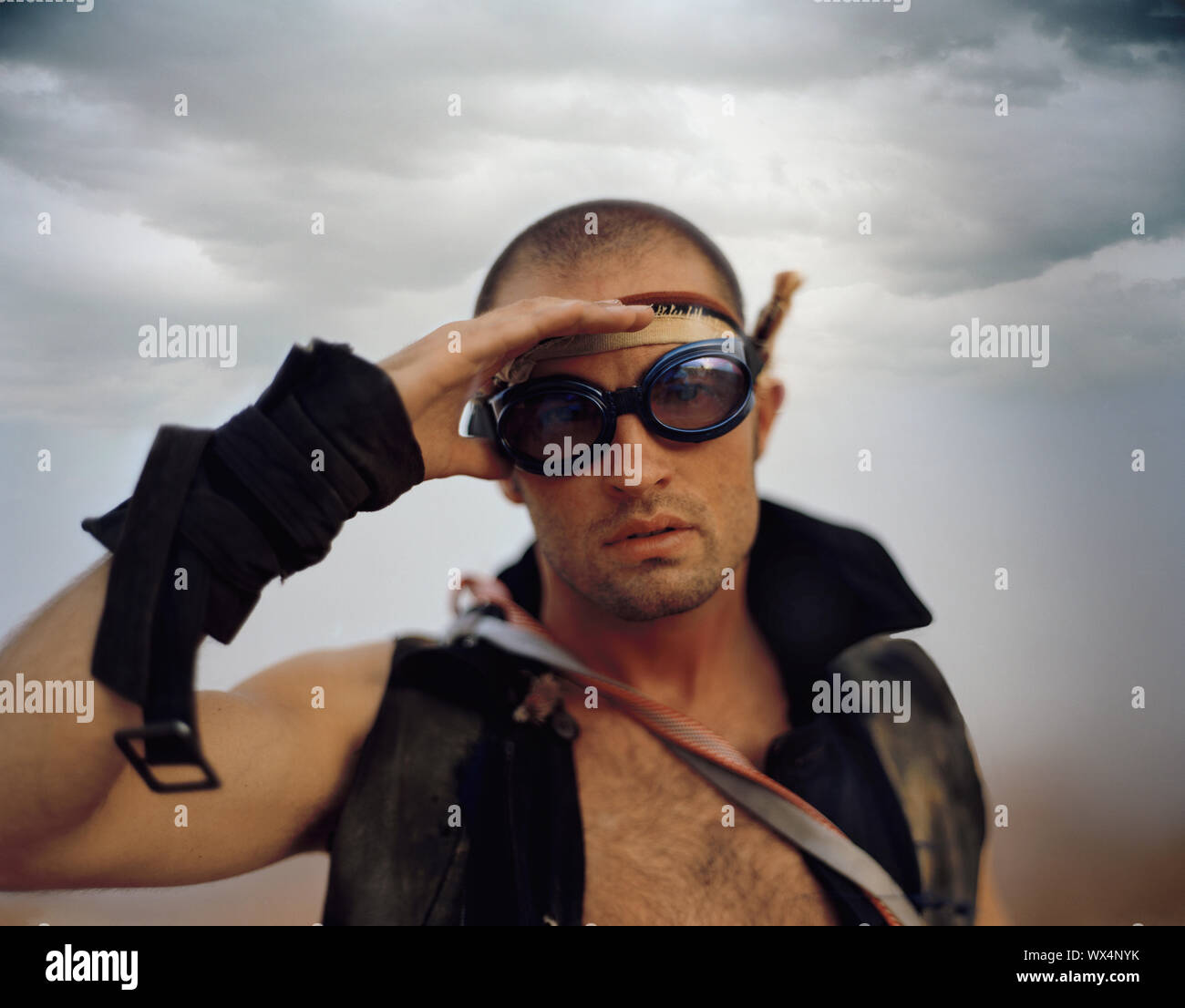 Retrato de un hombre adulto medio blindaje mientras sus ojos Gafas protectoras en un desierto. Foto de stock