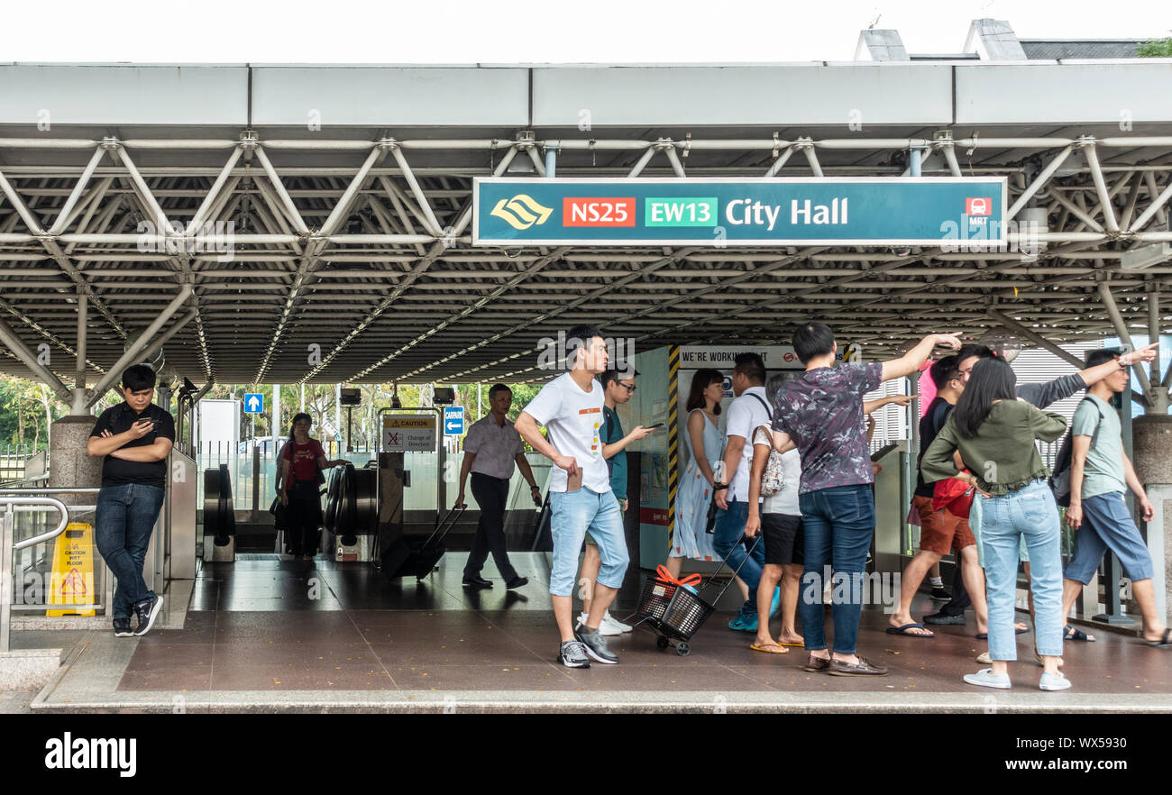Singapur - Marzo 20, 2019: el Ayuntamiento y la salida de la estación de MRT, sistema de tránsito rápido masivo de viajeros, con un montón de gente que sale y entra. Foto de stock