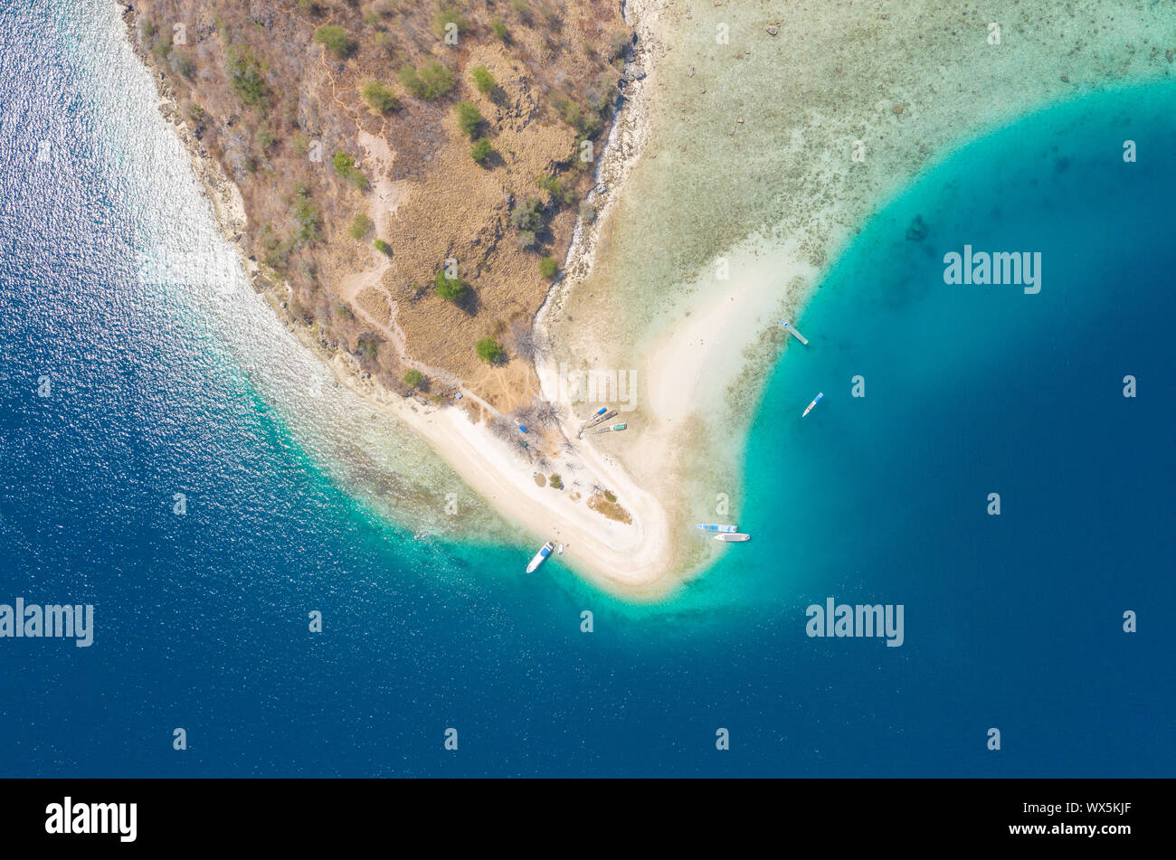 Vista aérea de la hermosa isla de Kelor drone con hermoso paisaje, playa de arena, mar azul, y arrecifes de coral y la montaña situado en Labuan Bajo, Foto de stock