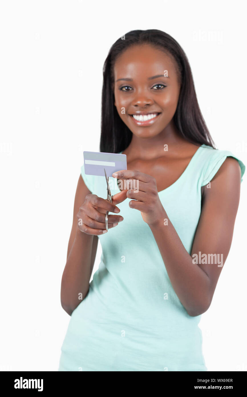 Feliz sonriente joven destruyendo tarjeta de crédito contra un fondo blanco. Foto de stock