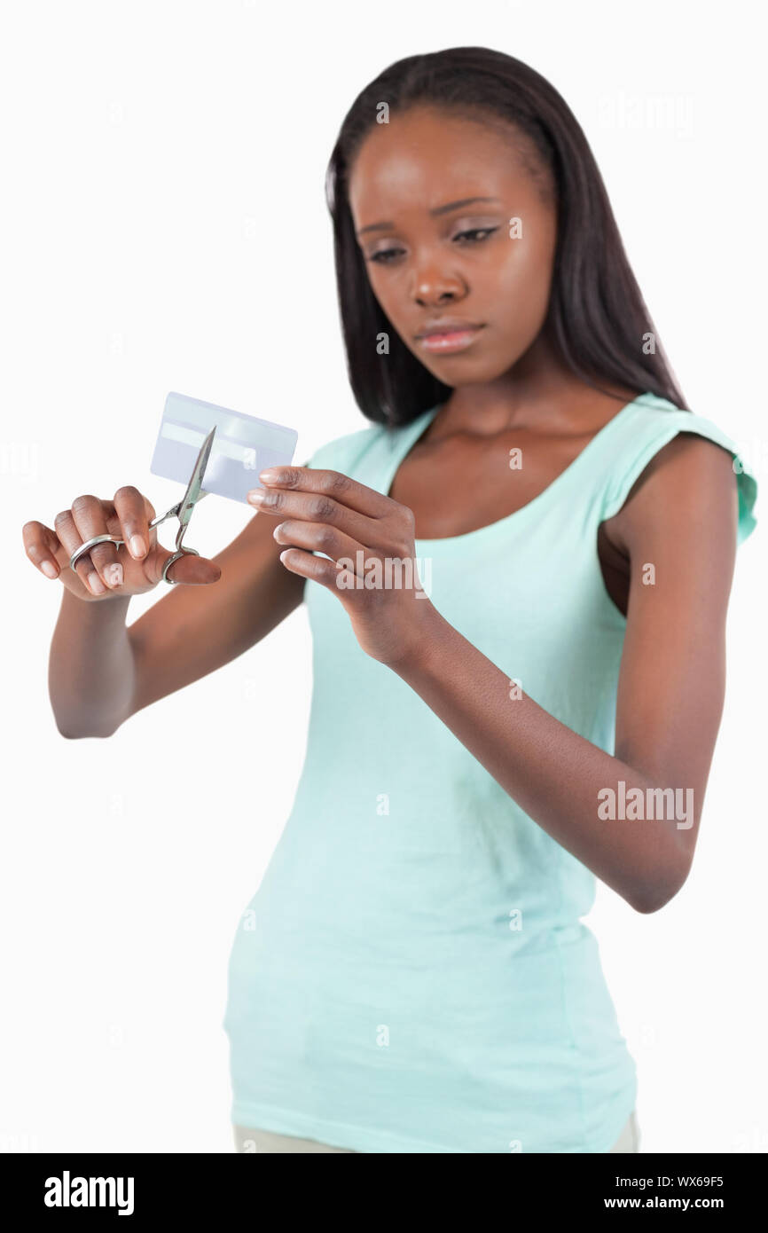 Triste buscando mujeres destruyendo su tarjeta de crédito contra un fondo blanco. Foto de stock