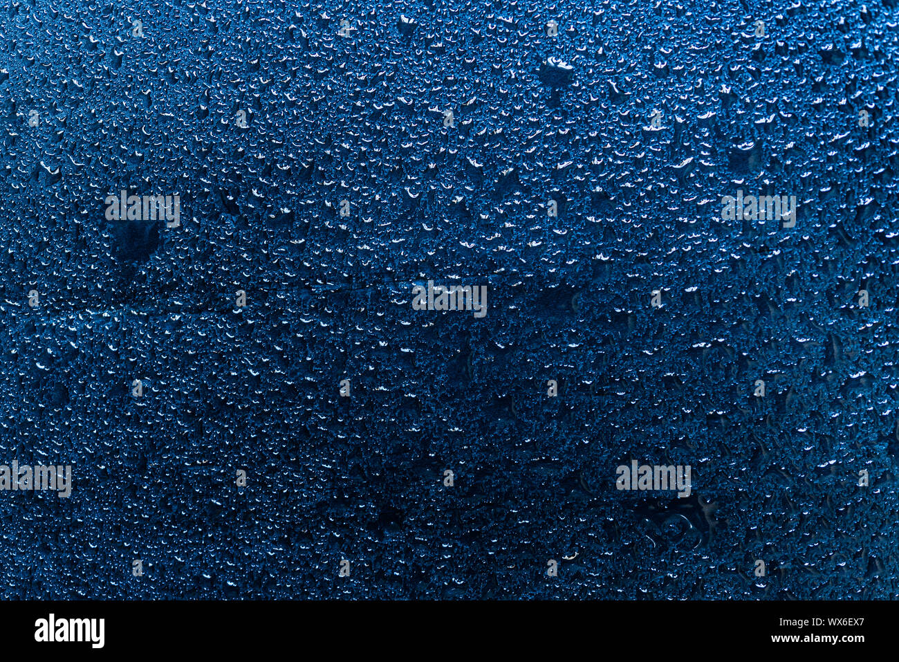 Gotas de agua sobre un fondo azul pizarra. Foto de stock
