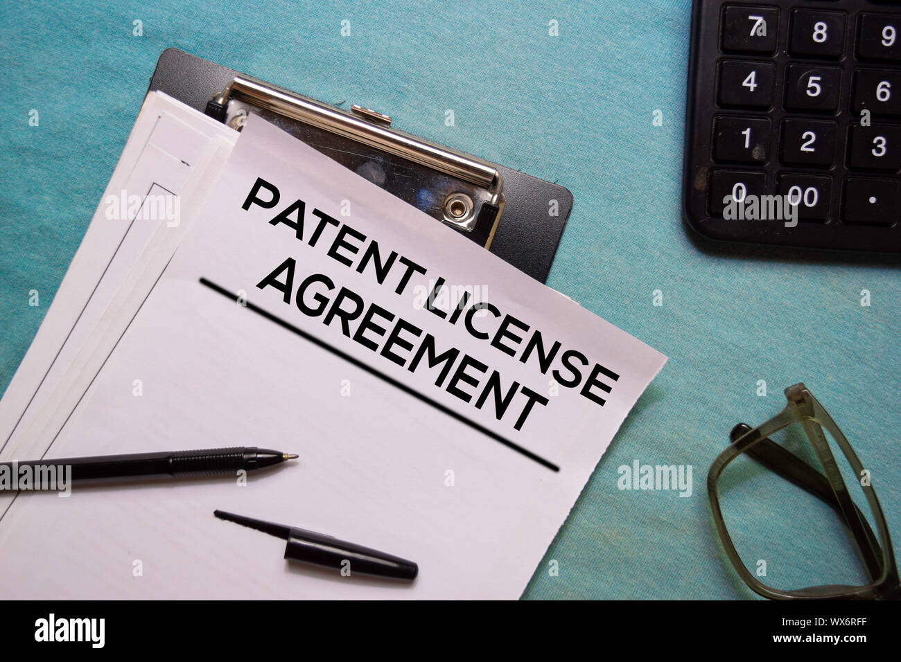 Acuerdo de licencia de patente en forma de documento de texto aislado en la oficina. Foto de stock